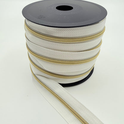 Glidelås metervare 6mm Spiral -  Metalllook Gull/Hvit (Pris oppgitt pr dm)